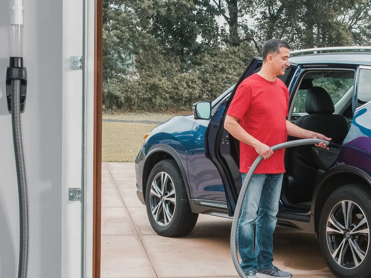 Cleaning a vehicle in the garage with a central vacuum hose